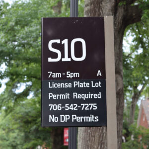 Parking lot sign for campus lot S10. 7am-5pm, License Plate Lot, Permit Required, 706-542-7275, No DP Permits